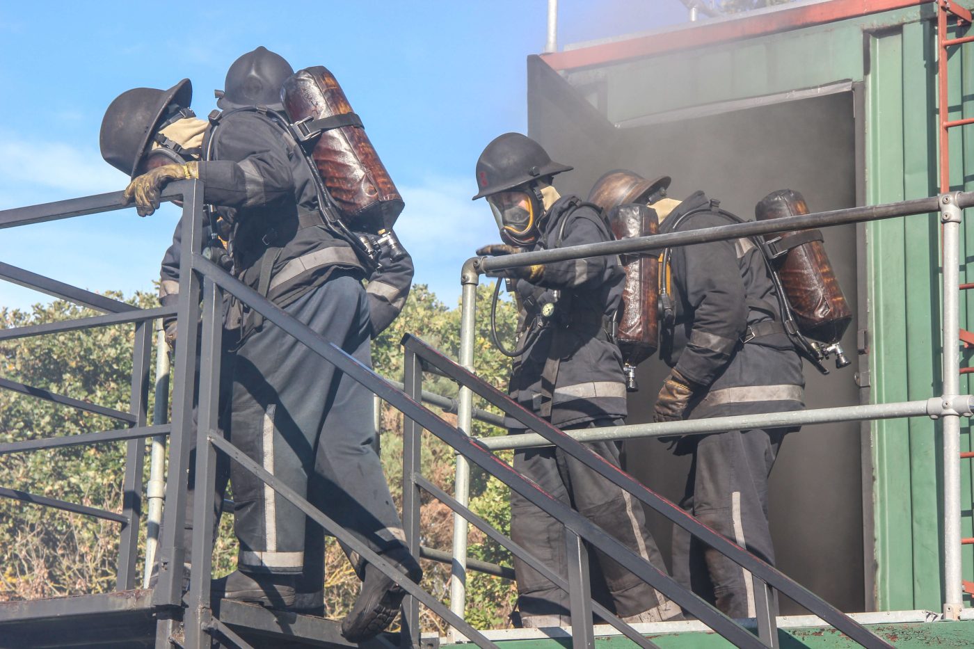 firefighters coming out of a smoking building