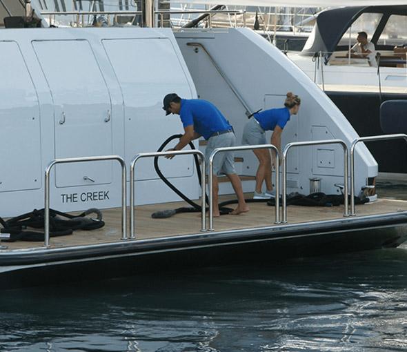 two people working on the back of a yacht